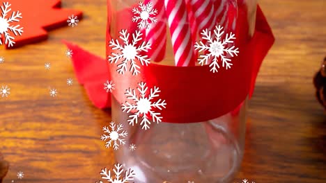Animation-of-snow-falling-over-candy-canes-and-christmas-decorations