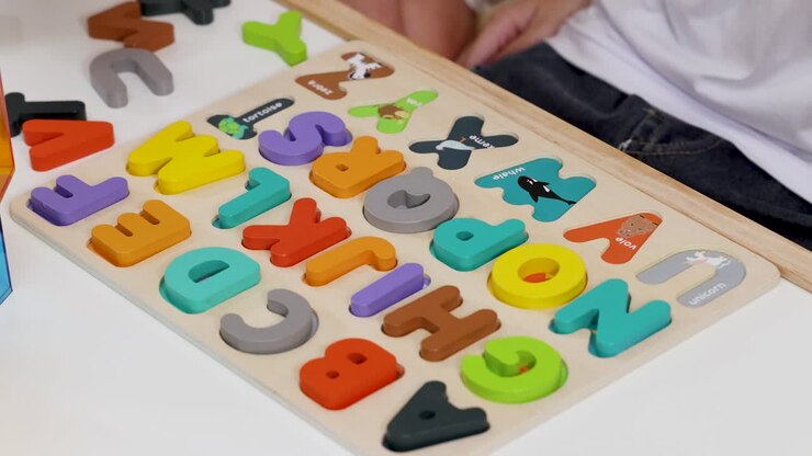 Two children arrange colorful wooden alphabet pieces on puzzle board in bright, well-lit room