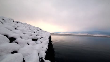 Disparo-Calmante-De-Un-Damm-Cubierto-De-Nieve-De-Cerca-Al-Nivel-Del-Agua,-Gaddins-Dam-Todmorden