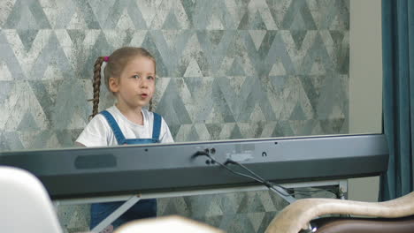 Un-Niño-Pequeño-Toca-El-Piano-Eléctrico-En-Casa.