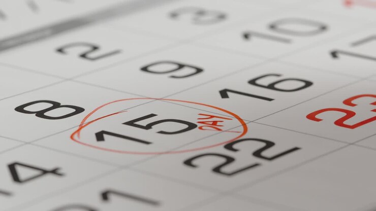 PRIMO PIANO: Segnare il giorno di paga su un calendario di carta con una penna rossa