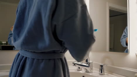 woman in bathrobe getting ready in bathroom