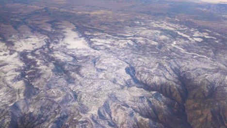 país montañoso glorioso desde una ventana de avión con nubes durante el viaje en un vuelo