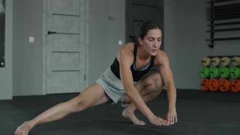 mujer estirándose en el gimnasio