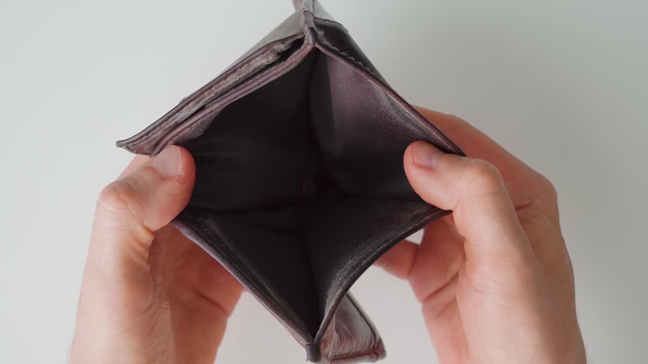Hombre abriendo una cartera vacía. Pobreza. Primer plano