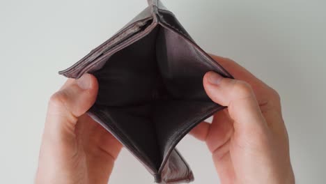 man opening an empty wallet. poverty. close up