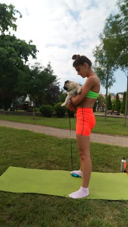 mujer haciendo ejercicio con un pug en un parque