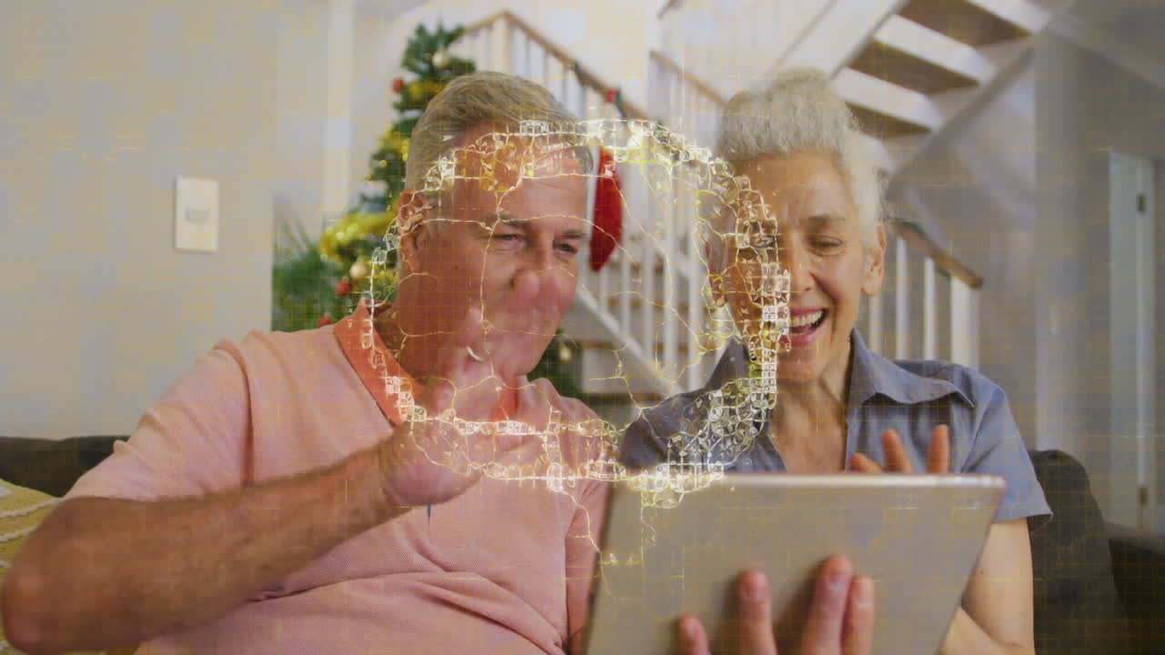 mature couple holding tablet on couch in home living room, with health tech brain hologram overlay