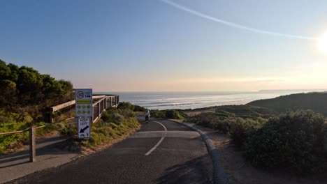 cyclist riding along scenic coastal road