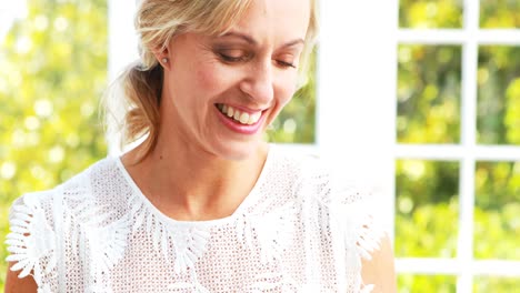 smiling beautiful woman text messaging on cell phone while having juice