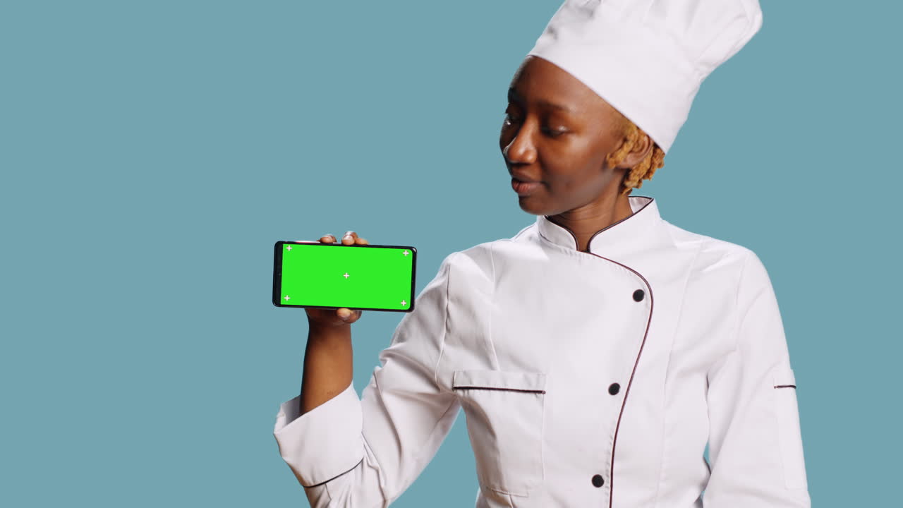 Chef afro-américain tenant un téléphone avec un écran vert