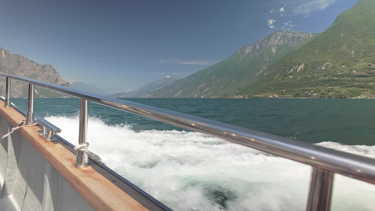 Fast ferry boat crossing lake with mountain views Starboard rail POV