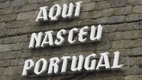 aqui nasceu portugal sign on stone wall