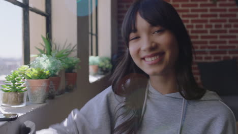 portrait young happy asian woman looking out window daydreaming student smiling enjoying successful lifestyle relaxing at home in trendy apartment