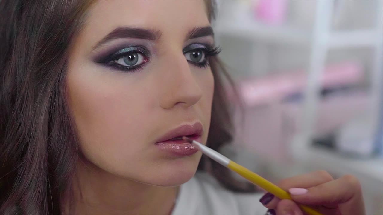 una mujer haciendo su maquillaje.