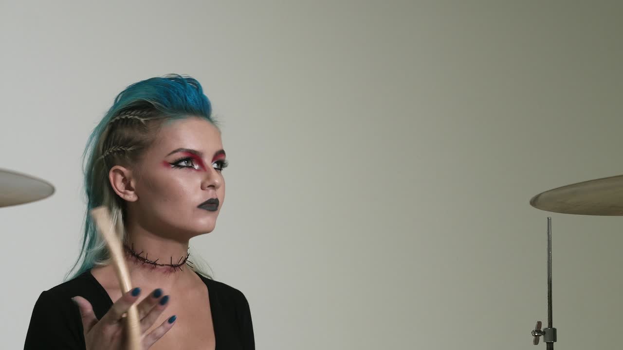 una chica caucásica con un escote profundo toca la batería.