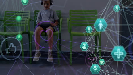 animation of globe of connections with icons over caucasian boy patient with tablet