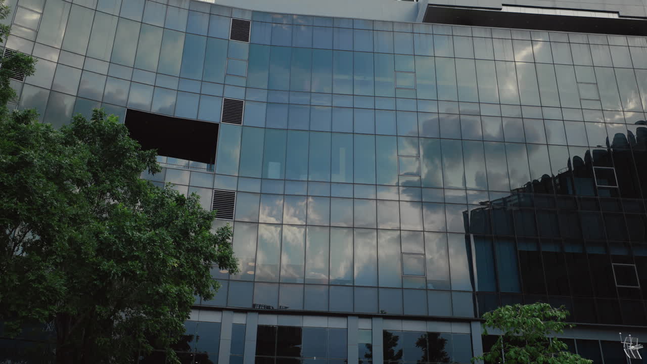 Modern Office Building with Glass Facade and Cloud Reflections