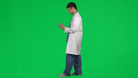 male doctor writing a prescription against green screen