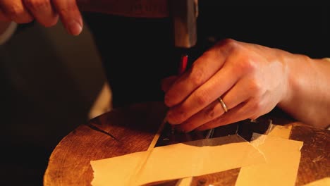 hands meticulously cutting paper with a craft knife