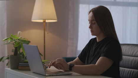 mujer independiente está trabajando con una computadora portátil en casa por la noche sintiendo dolor en el cuello osteocondrosis y enfermedades de la columna vertebral de los trabajadores de oficina modernos