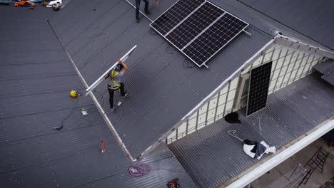 worker carrying solar panel on roof of new and modern house