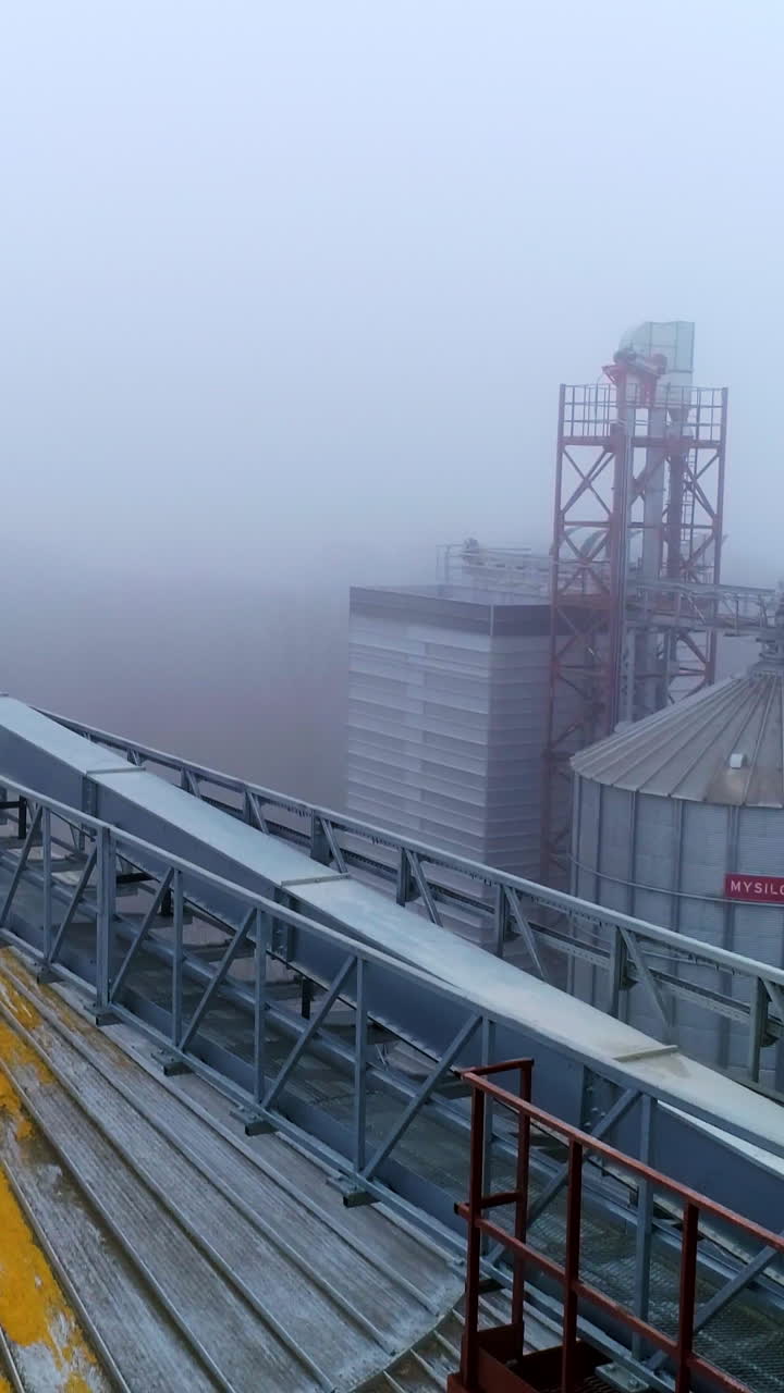 Factory steel building containers. Big industrial elevator storage aerial view. Vertical video