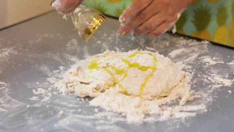 pouring olive oil over dough