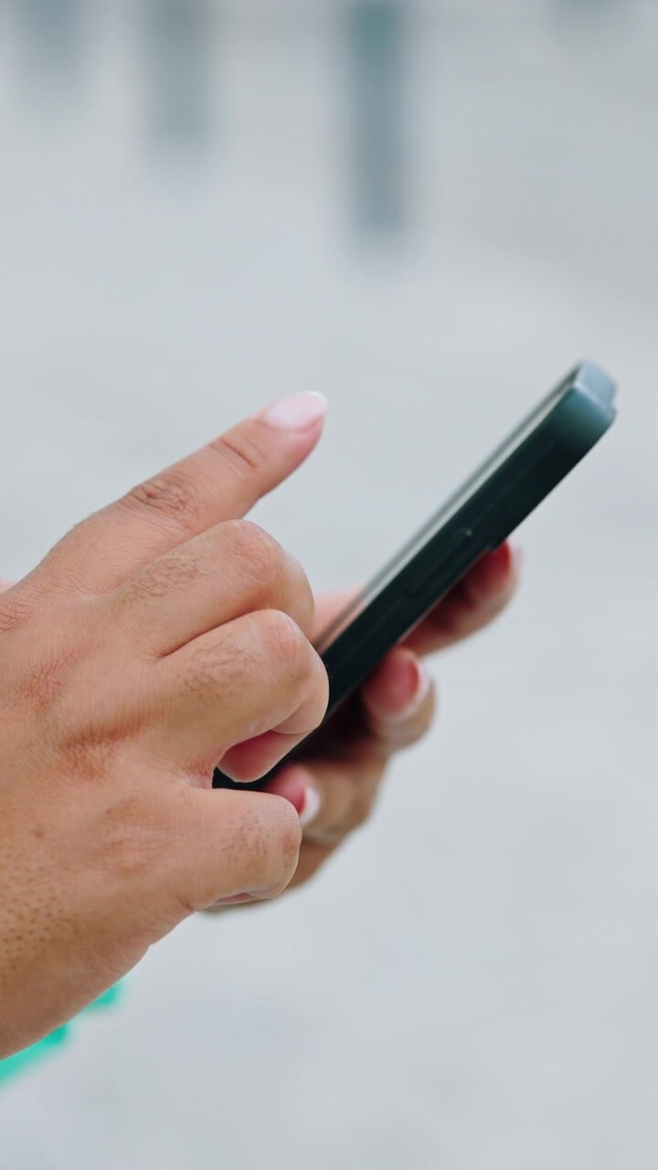 Primo piano di una persona che usa uno smartphone all'aperto