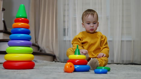 niño pequeño jugando con anillos apilados