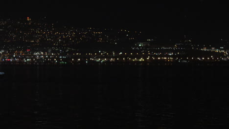 Paisaje-Urbano-De-Noche-Con-Barco-En-El-Agua