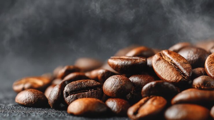 A Captivating Close-Up of Aromatic Roasted Coffee Beans, Showcasing Their Rich Textures and Deep Brown Hues with a Hint of Steam Rising in the Background
