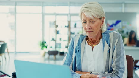 senior woman working on laptop in modern office