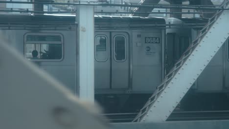 Aus-Dem-Fenster-Einer-Sich-Bewegenden-New-Yorker-U-bahn-Blicken-Und-Einen-Anderen-Zug-Mit-Gleicher-Geschwindigkeit-über-Die-Manhattan-Bridge-Fahren-Sehen,-Mit-Der-Skyline-Im-Hintergrund-Pov-Shot