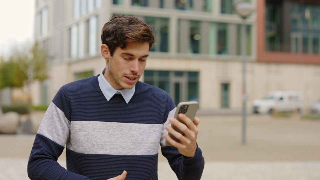 Man using smartphone outdoors in urban setting