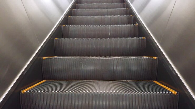 Vista da escada rolante subindo para a plataforma na estação de trem