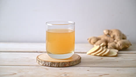 vaso de jugo de jengibre fresco y caliente con raíces de jengibre - estilo de bebida saludable