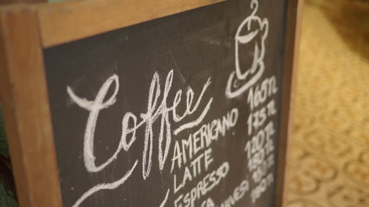 Kaffemenu på tavle, der viser drikkevarer og priser