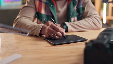man using a graphic tablet on a wooden desk