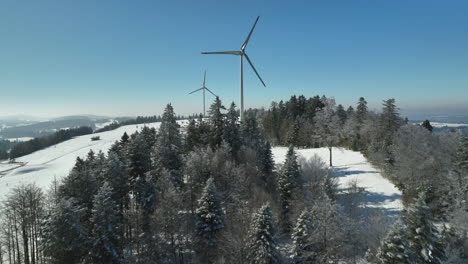 Dos-Molinos-De-Viento-Gigantes-Modernos-Girando-En-El-Viento-En-La-Cima-De-La-Montaña-Jura-En-Suiza-En-Un-Soleado-Día-De-Invierno