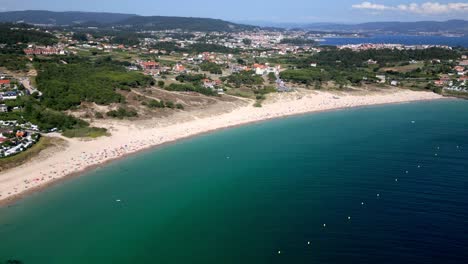Breathtaking-Aerial-Footage-of-Wide-Beach-and-Jade-Water-in-Coastal-Village