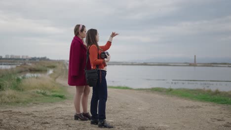 two women exploring a salt marsh landscape