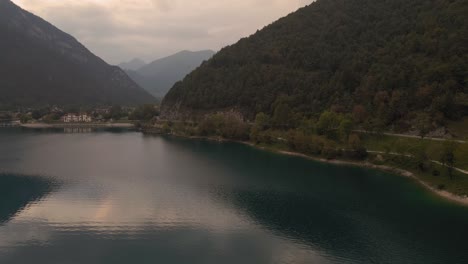 Coast-of-Lago-di-Ledro-in-Northern-Italy-with-footpath-surrounding-lake,-aerial