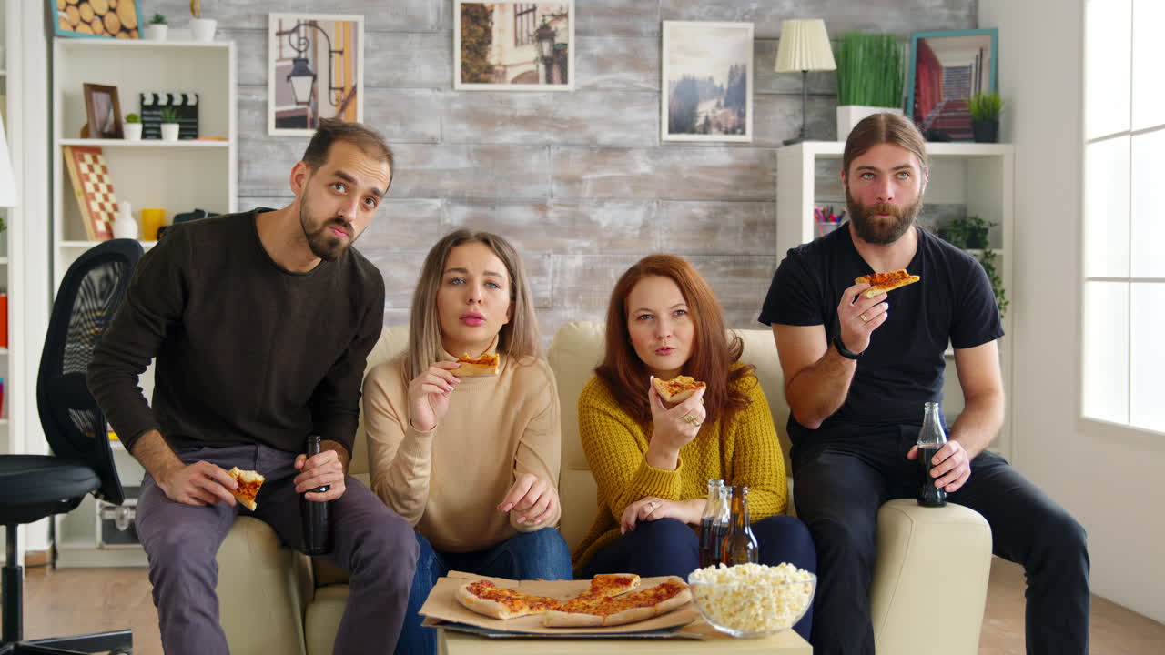 Amici intimi che guardano una serie TV seduti sul divano