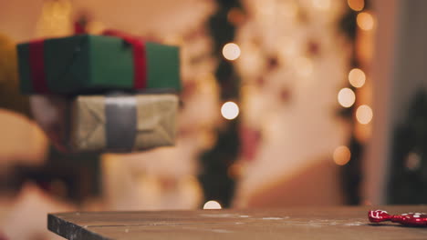 la mano de 4k pone una caja de regalo envuelta debajo del árbol de navidad