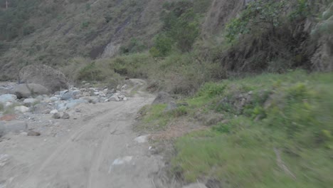 mountain dirt road vehicle tracks leading out to riverbed opening boulders rocks sand i valley kabayan benguet philippines fast reverse reveal aerial