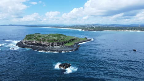 large rock island formation rising from the ocean creating a natural ecosystem