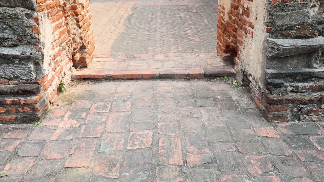 관광객이 역사적인 사원에 있는 부처 동상에 접근합니다.