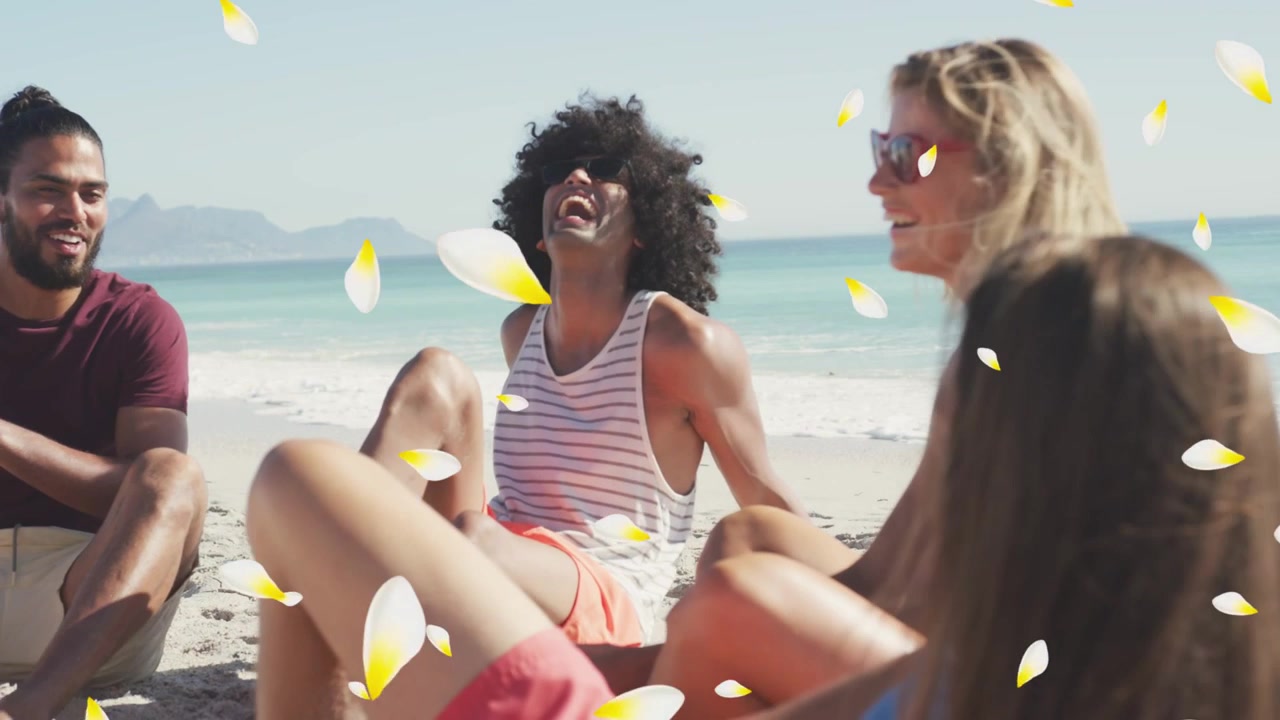 Uomo al centro che si tocca il labbro dopo uno scherzo, un gruppo ridente si unisce, petali che fluttuano su di loro in spiaggia, viaggio