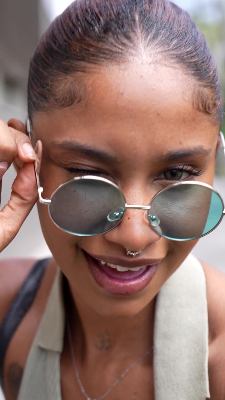 Playful Young Woman Smiling and Posing in Sunglasses